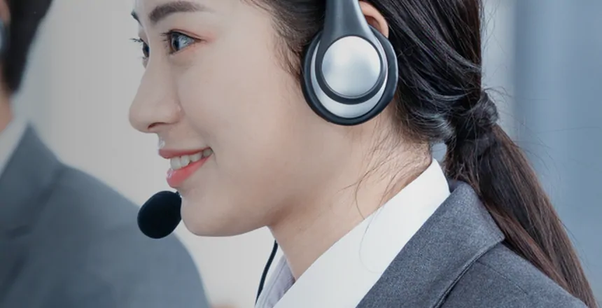 An AllChinaBuy support agent at a desk wearing a headset